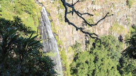 Waterfall tumbling over sheer rock cliff.