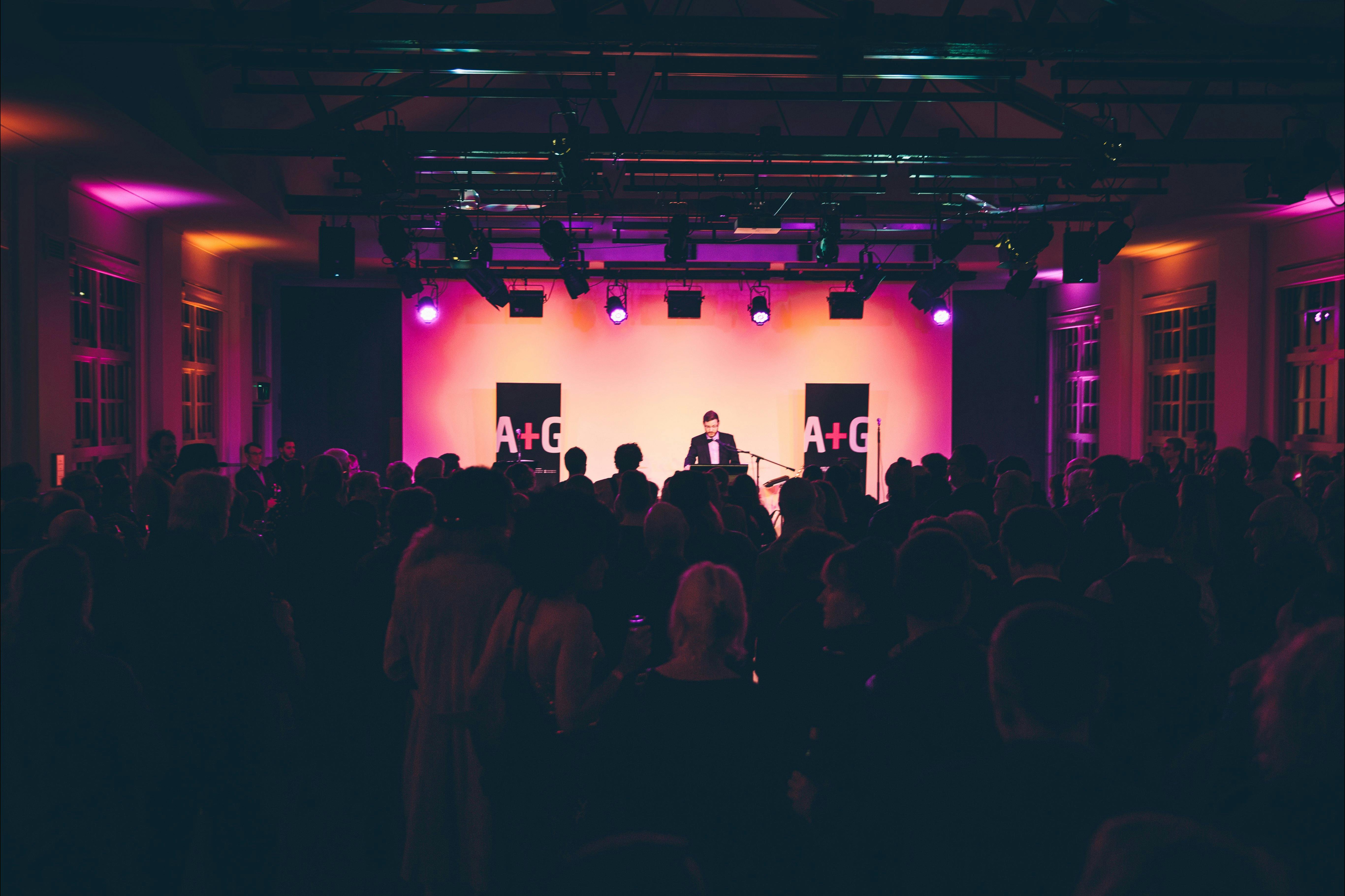 An event in the Main Hall at the Ainslie Arts Centre. Large crowd of people turned towards the stage