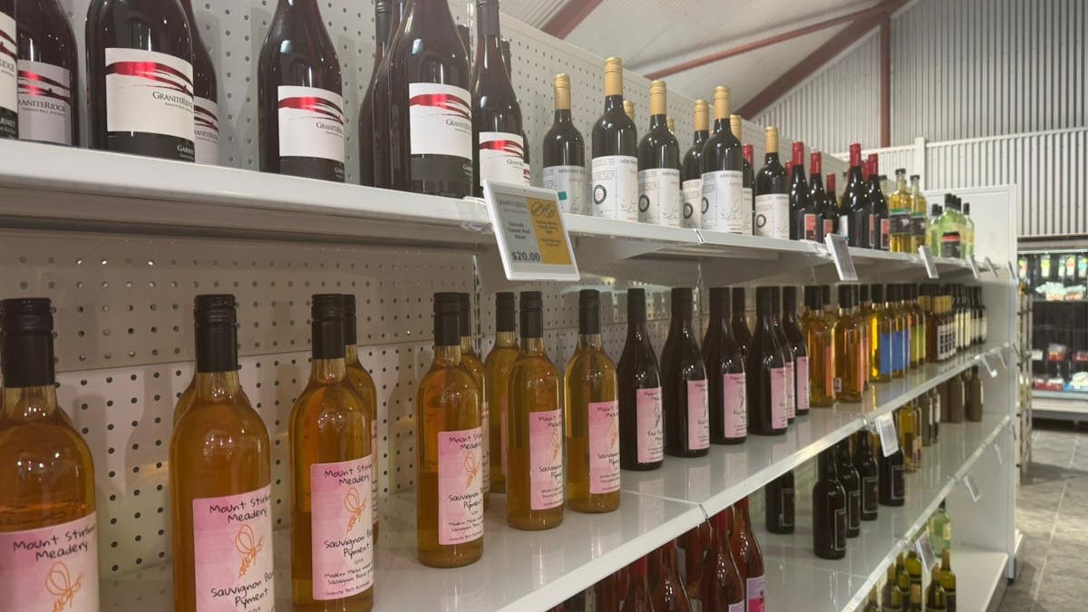 Shelves stocked with a variety of wines and mead bottles inside a store.