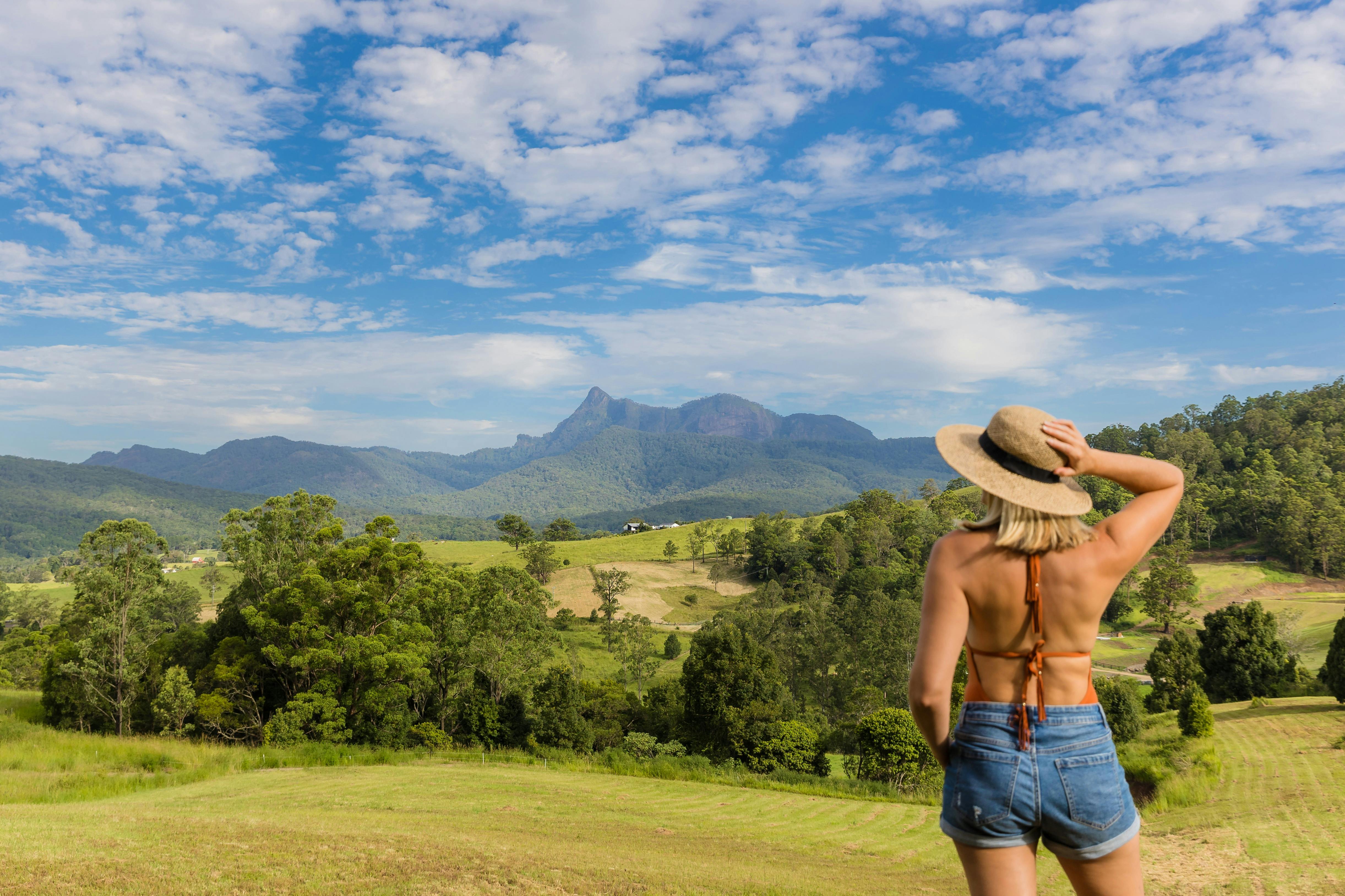 모자를 쓰고 멀리 있는 산을 바라보는 여인