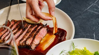 Sliced steak with chip dipped in gravy