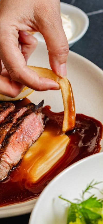 Sliced steak with chip dipped in gravy
