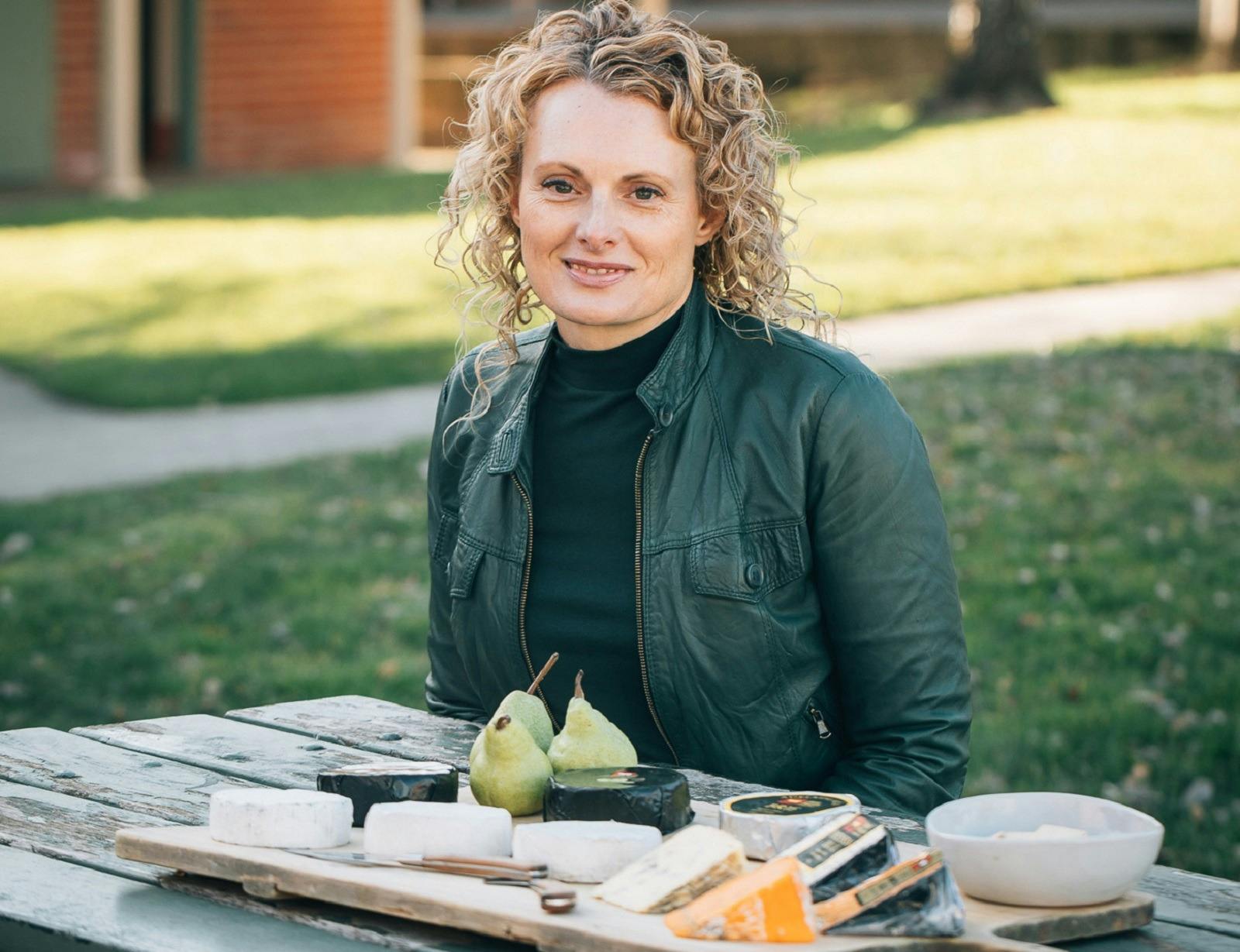 Woman sitting at table with cheese platter