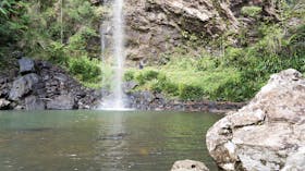 People walking behind waterfalls