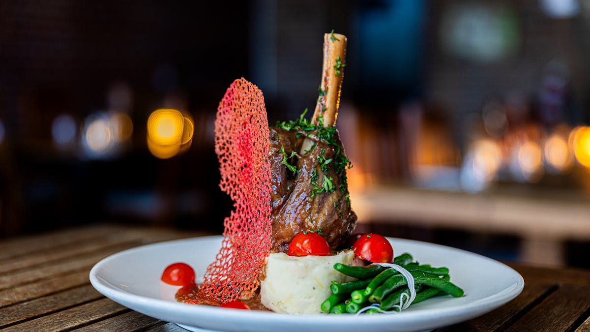 Slow cooked lamb shanks with creamy garlic mash and seasonal vegetables.