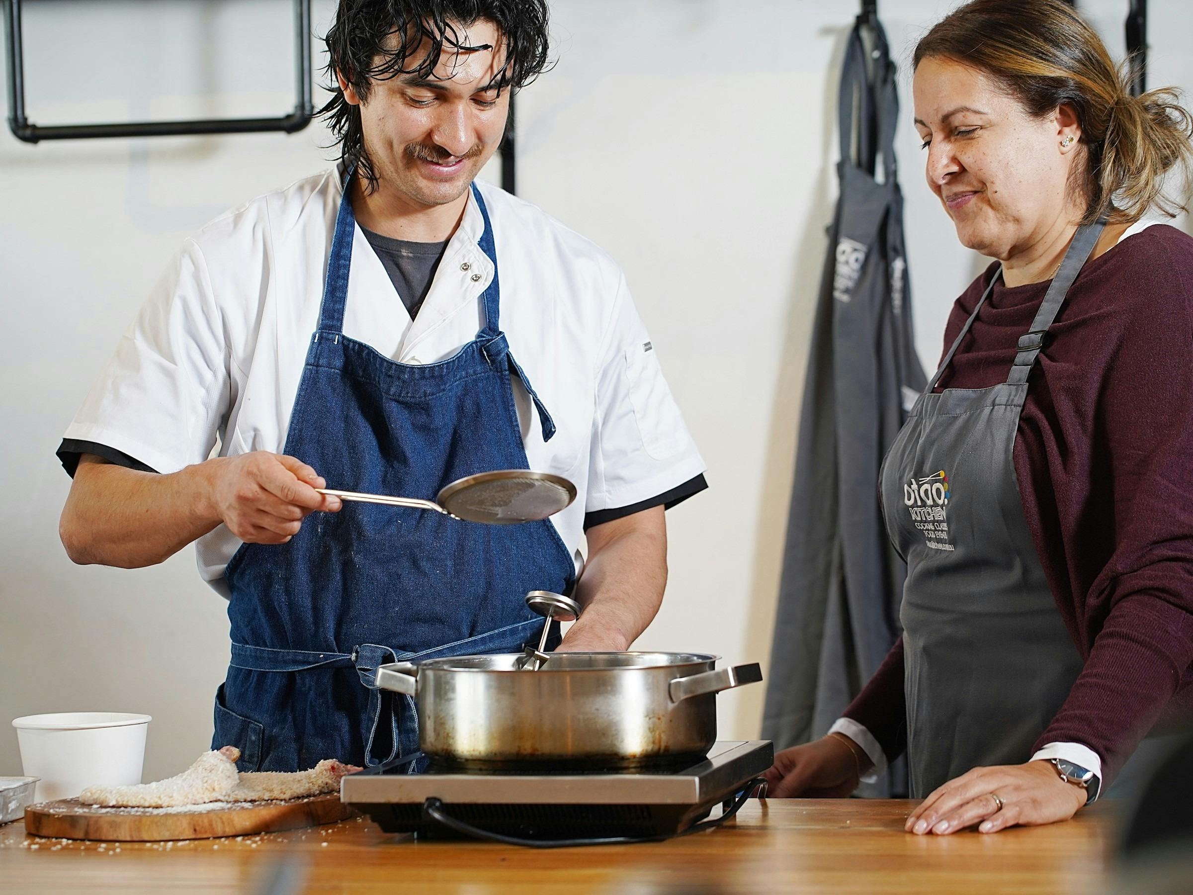 Chef and guest cooking together during a full-day workshop