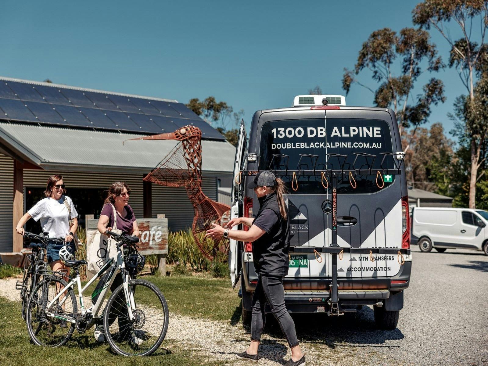 Guests with bikes meet their Double Black Alpine shuttle. DBA team member extends a warm welcome