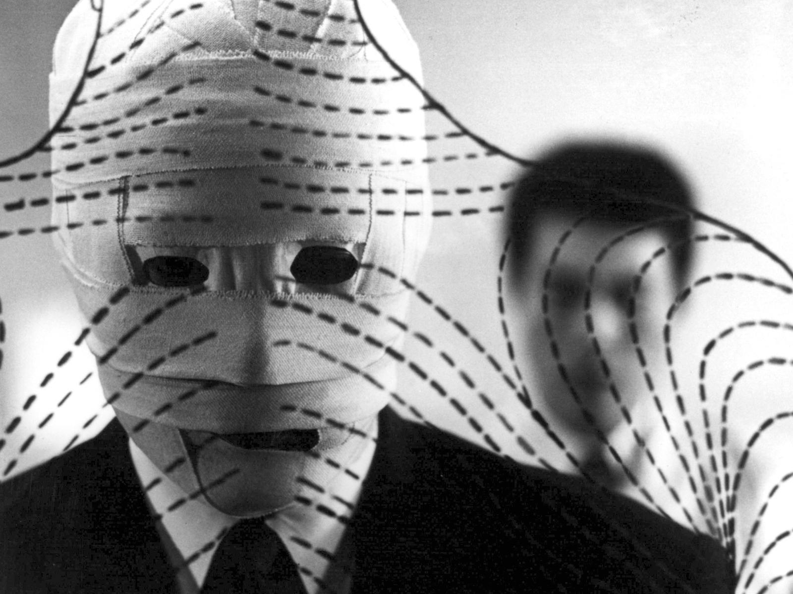 Black and white image of man with face covered in bandages