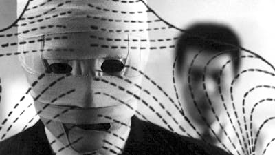 Black and white image of man with face covered in bandages