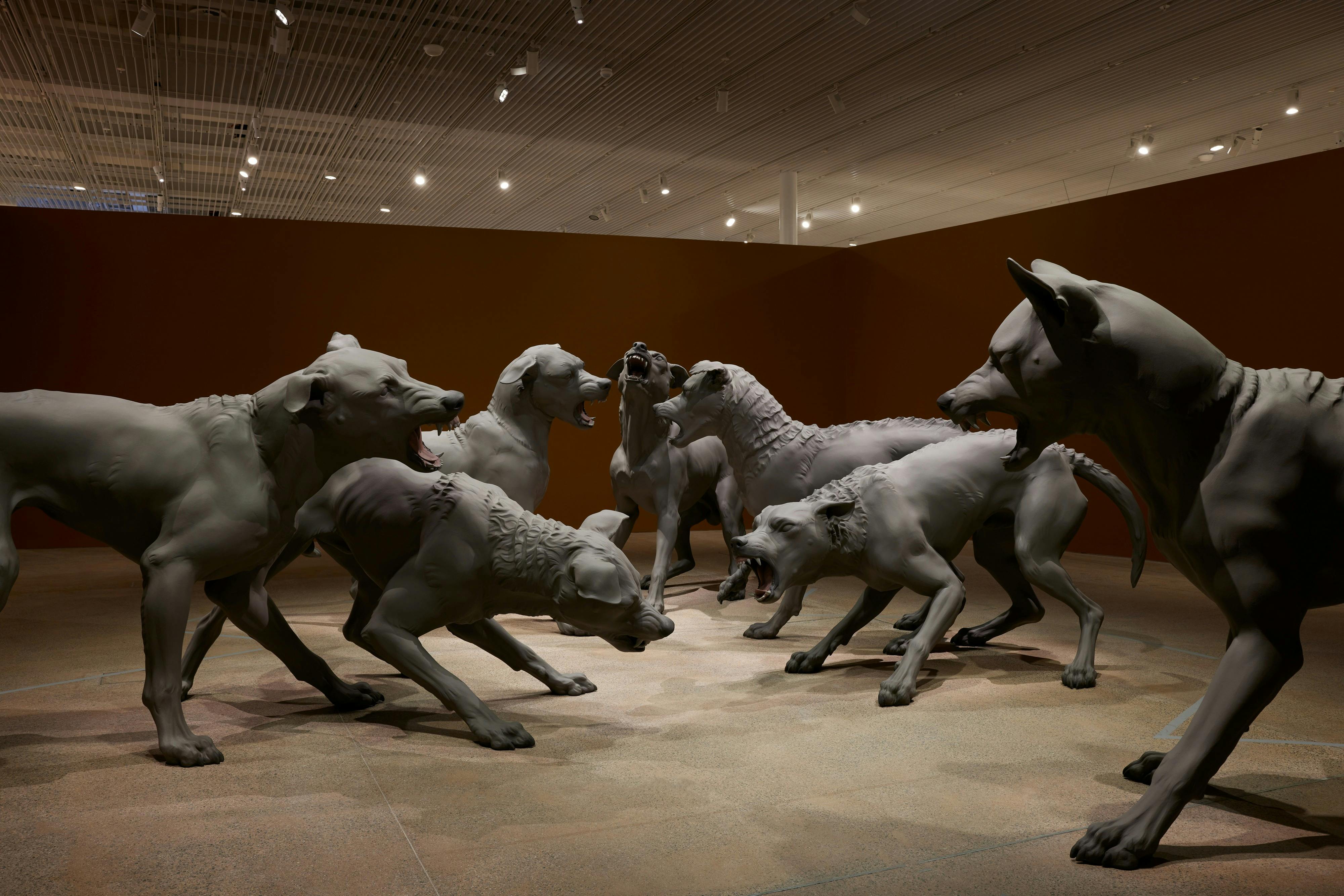 Hyper realistic sculptures of a snarling pack of dogs