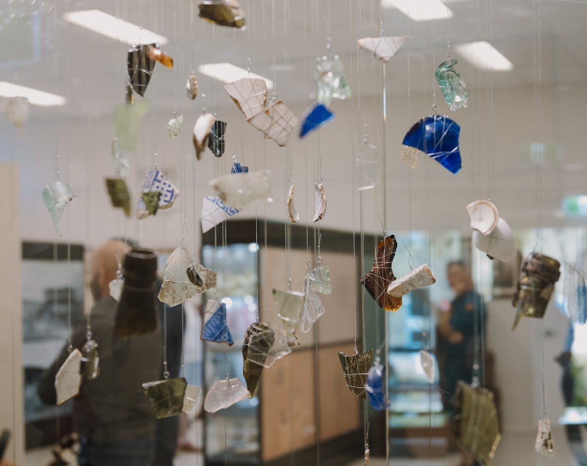 Fragments of glass and ceramic from the 1916 Clermont flood are suspended in a display case.
