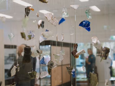Fragments of glass and ceramic from the 1916 Clermont flood are suspended in a display case. Fragments of glass and ceramic from the 1916 Clermont flood are suspended in a display case.