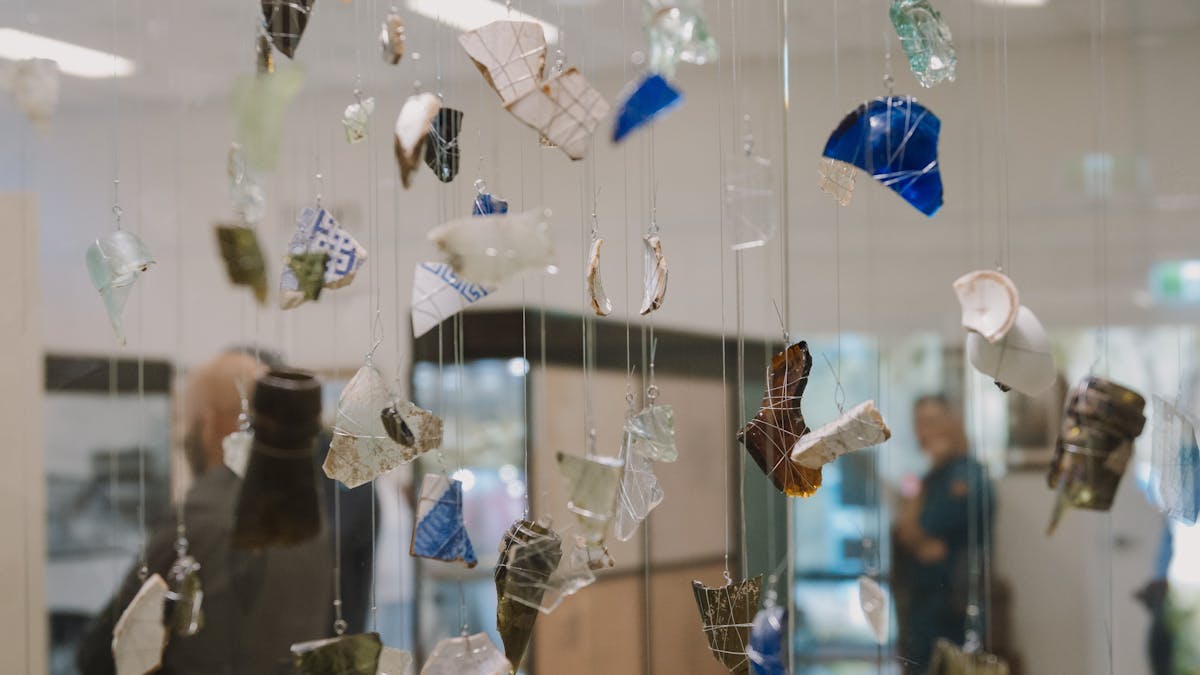 Fragments of glass and ceramic from the 1916 Clermont flood are suspended in a display case.