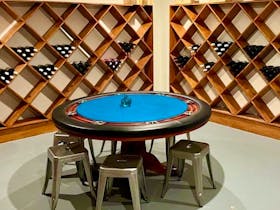 Wine cellar with wine for selection by guests and a poker table seating 6 for games