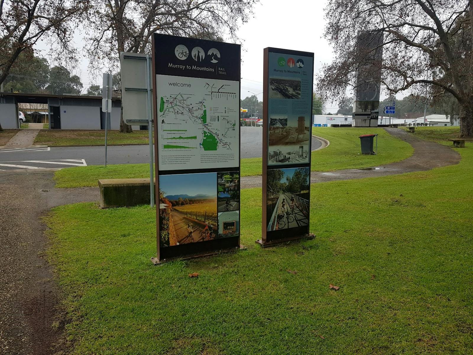 grass, directional signs for rail trail, path, toilet block, seats