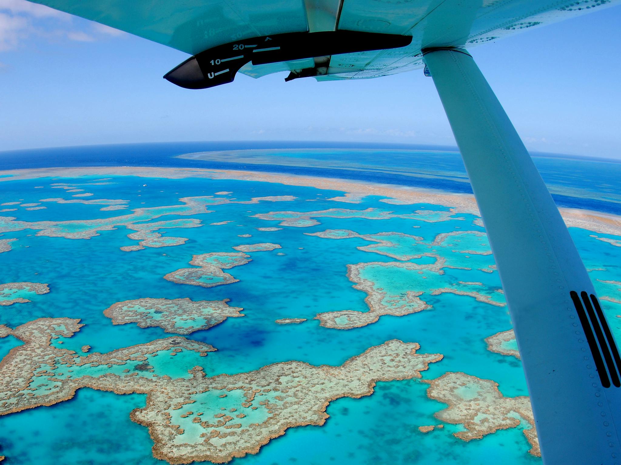 Aerial view of the calm turquoise water surrounded by coral reefs including heart shaped reef Aerial view of the calm turquoise water surrounded by coral reefs including heart shaped reef