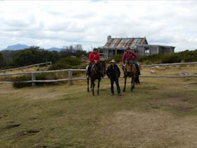 Two riders on horseback in front of Craigs Hut