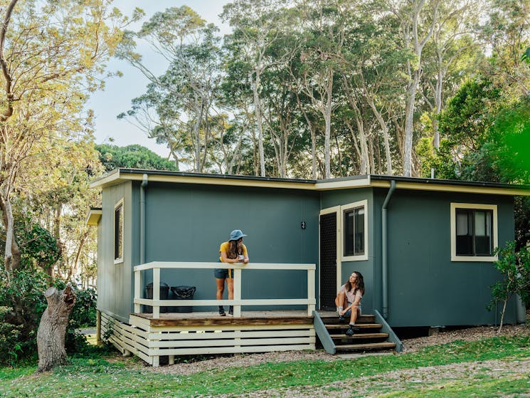 Two people outside a cabin at Depot Beach.