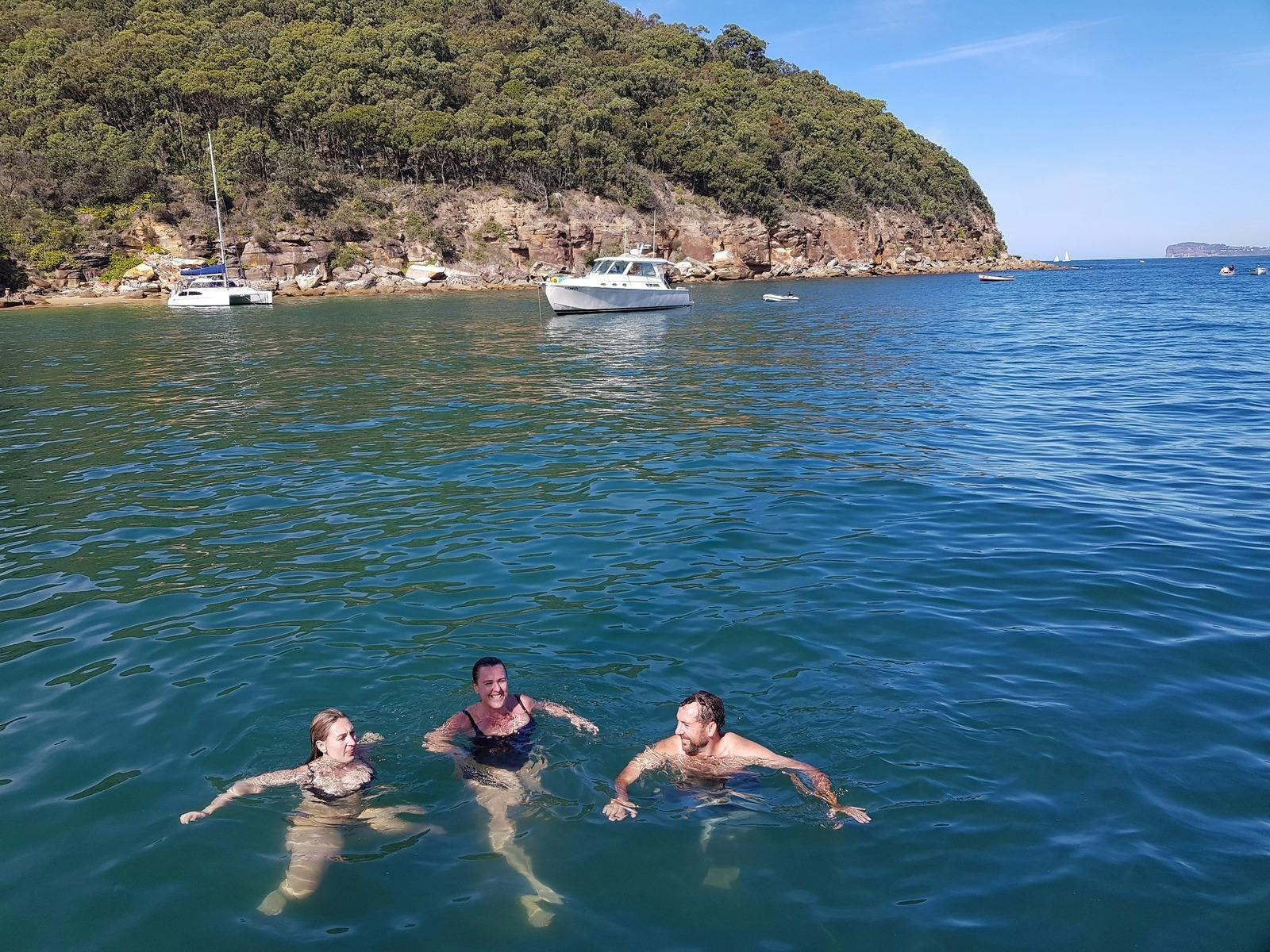 Guests swiming off a sailing catamaran in Broken Bay, NSW, Australia