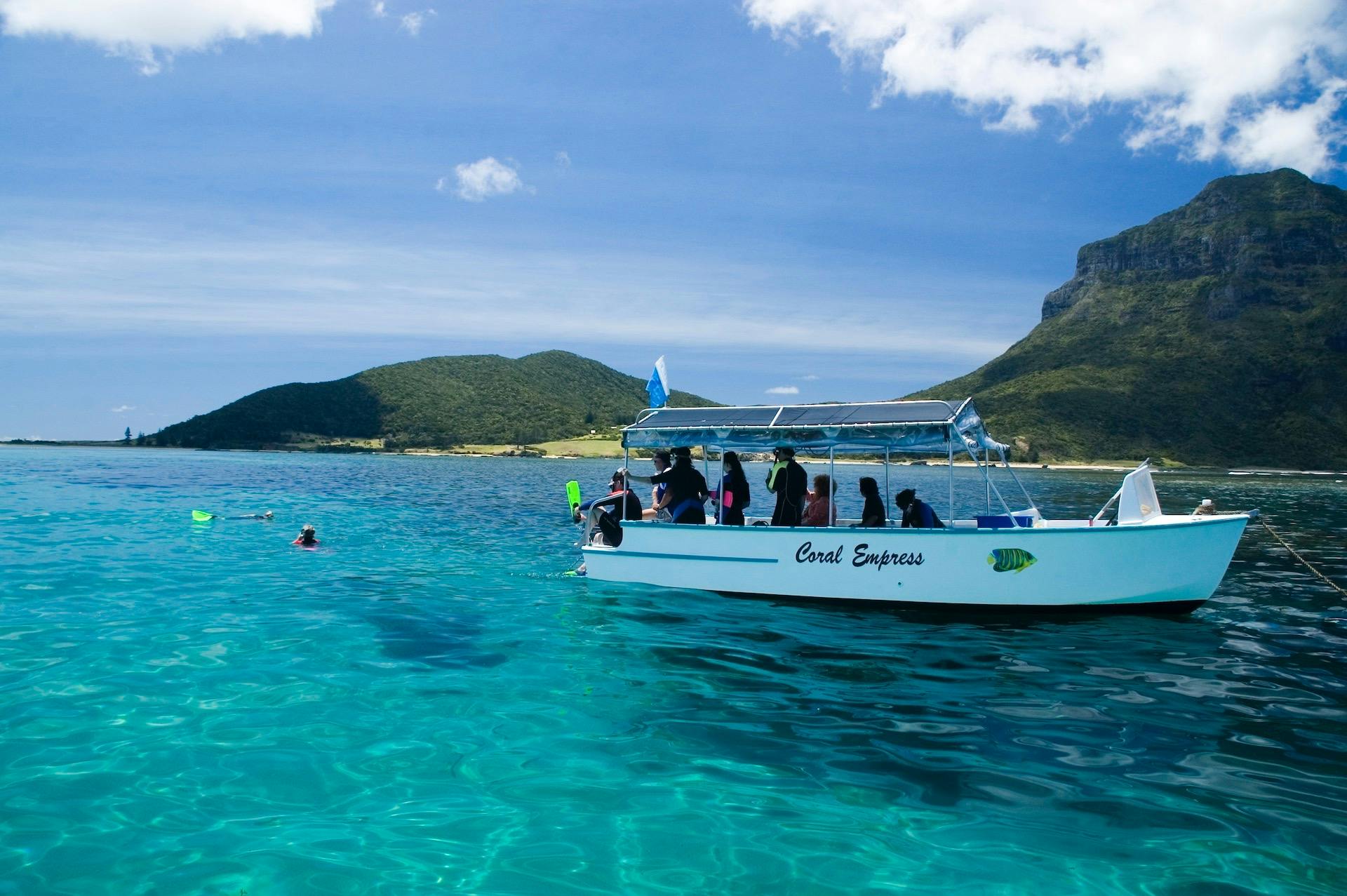 The glass bottom boat "Coral Empress" and snorkellers in the water.