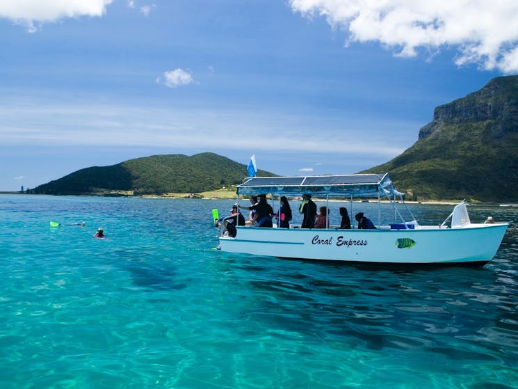 The glass bottom boat "Coral Empress" and snorkellers in the water.