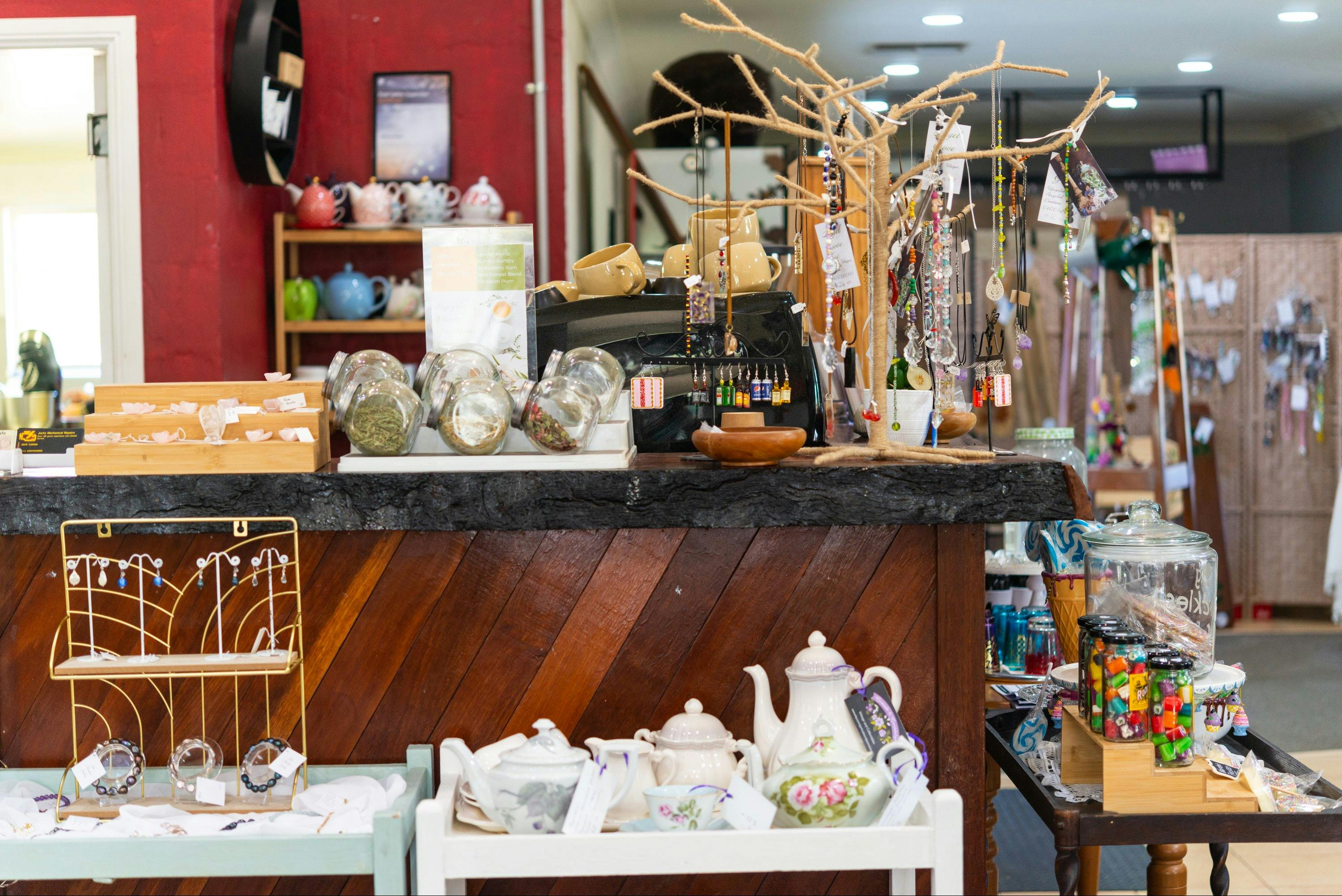 Shelves with a variety of items to buy: jewellery, ceramic teapots, lollies and more.