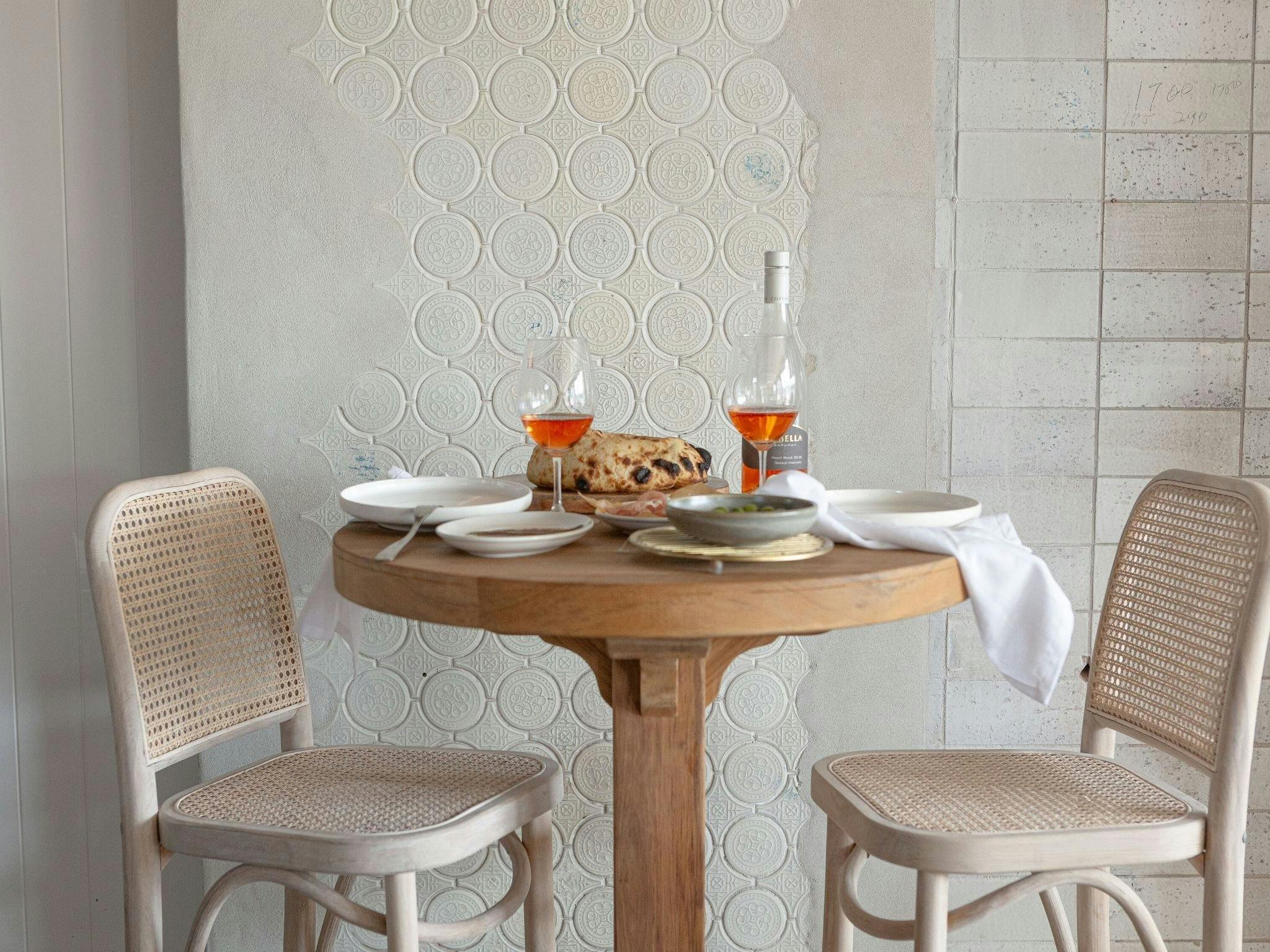 Table and bar stools with rose wine and snacks
