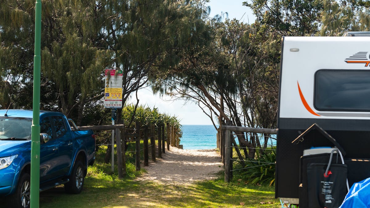 Picture of beach entrance access from caravan park with caravan to the side of frame.