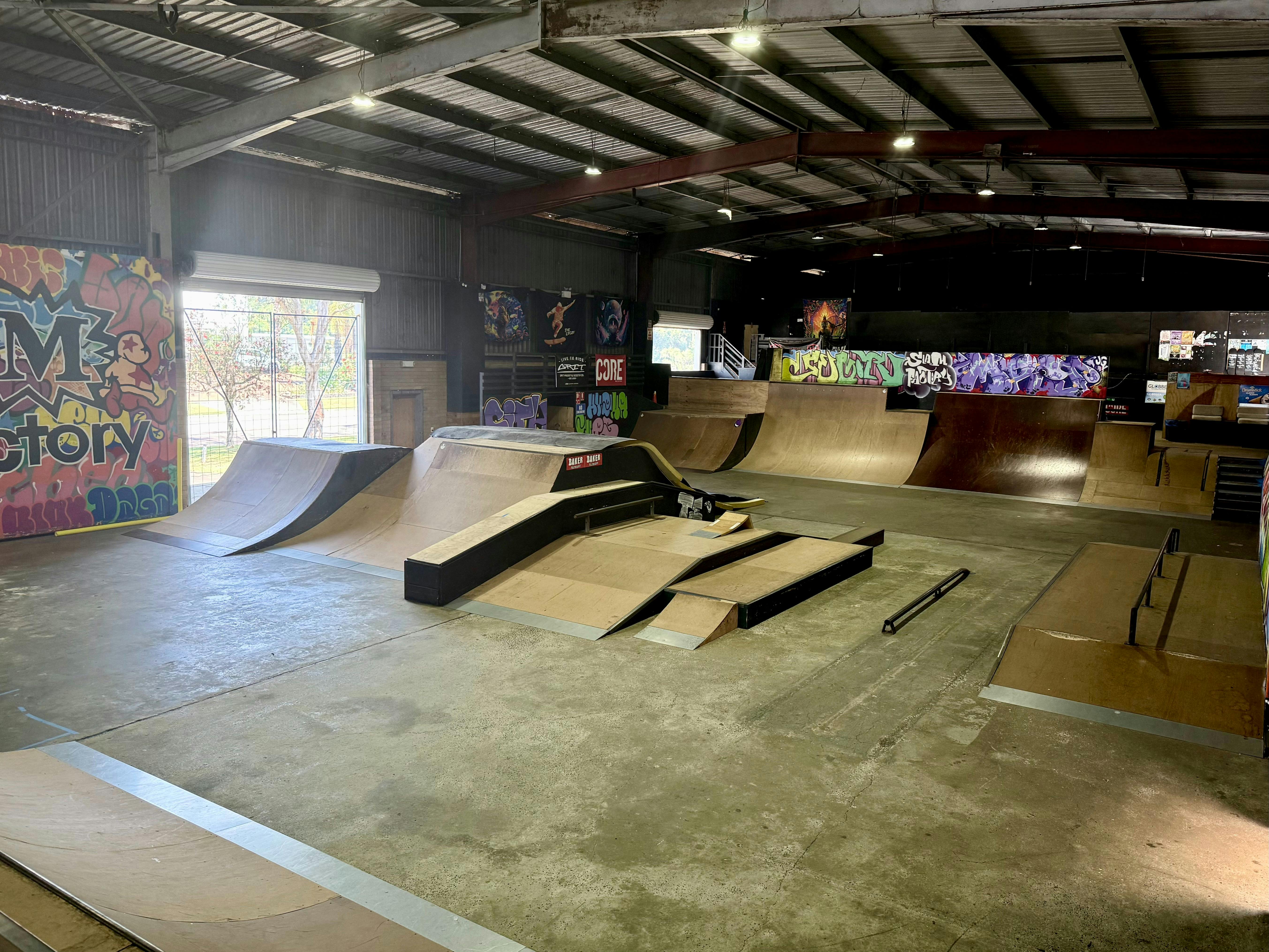 Street-style ramps, rails, and boxes inside Slam Factory Indoor Skatepark.