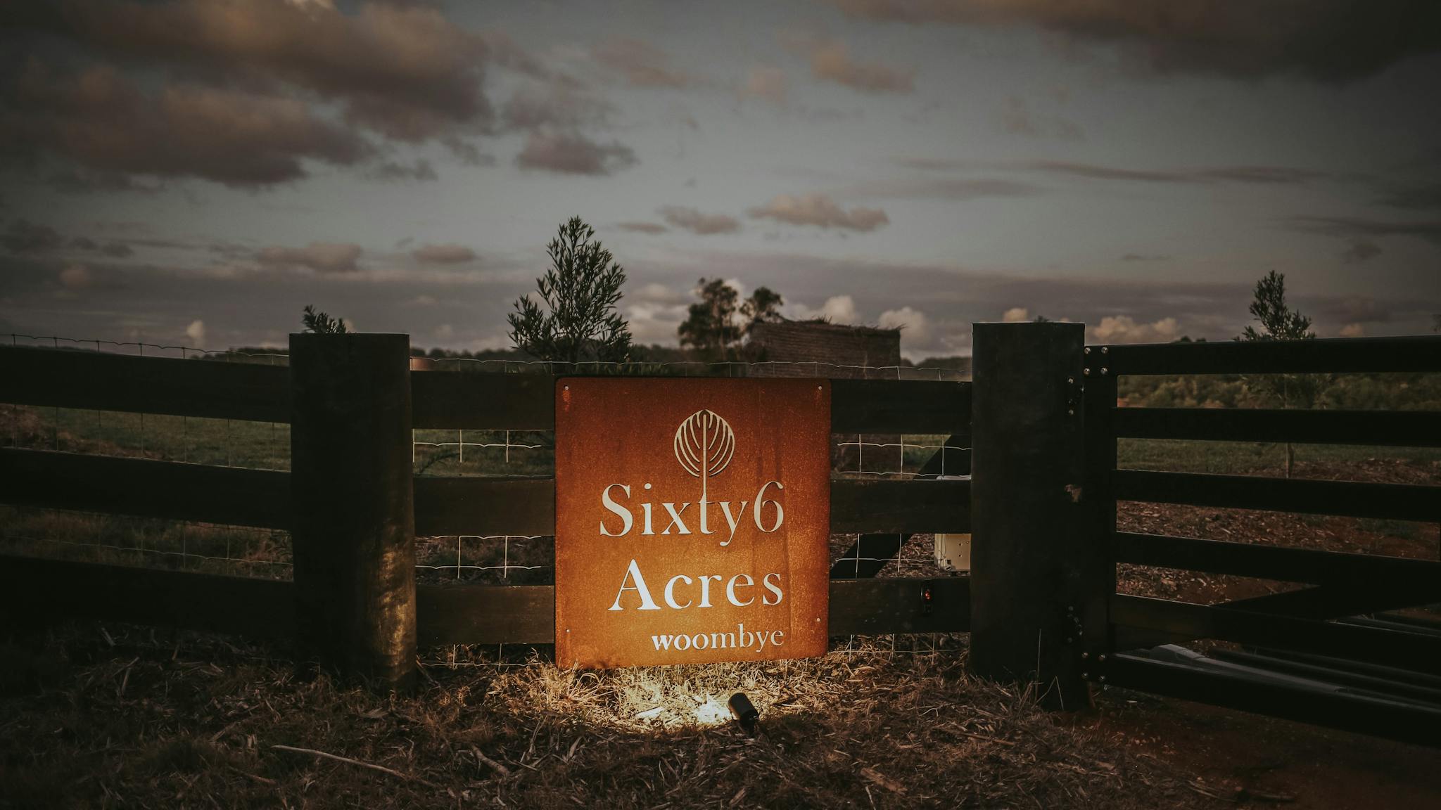 Sixty6 Acres entry sign at the front gate at dusk Sixty6 Acres entry sign at the front gate at dusk