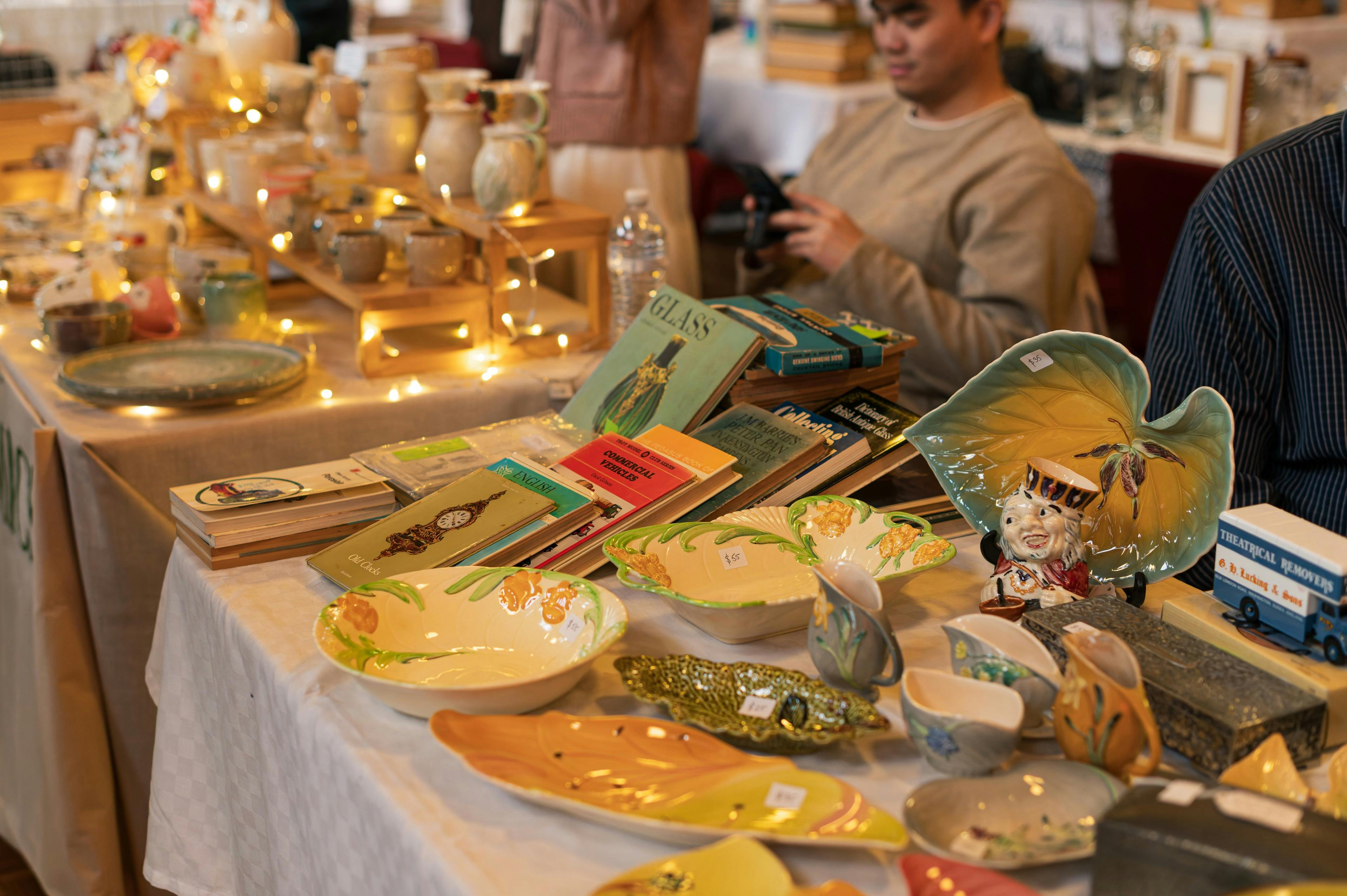A market table covered in vintage books and ceramics.