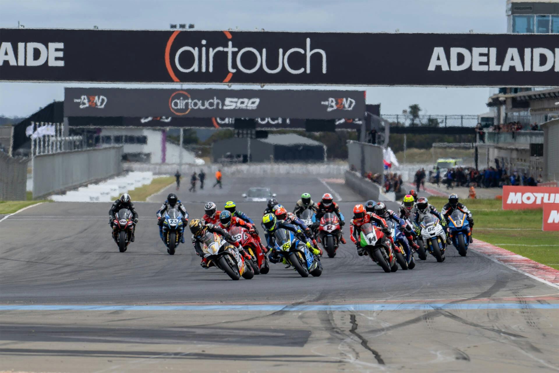 A group of Superbikes race around turn 1