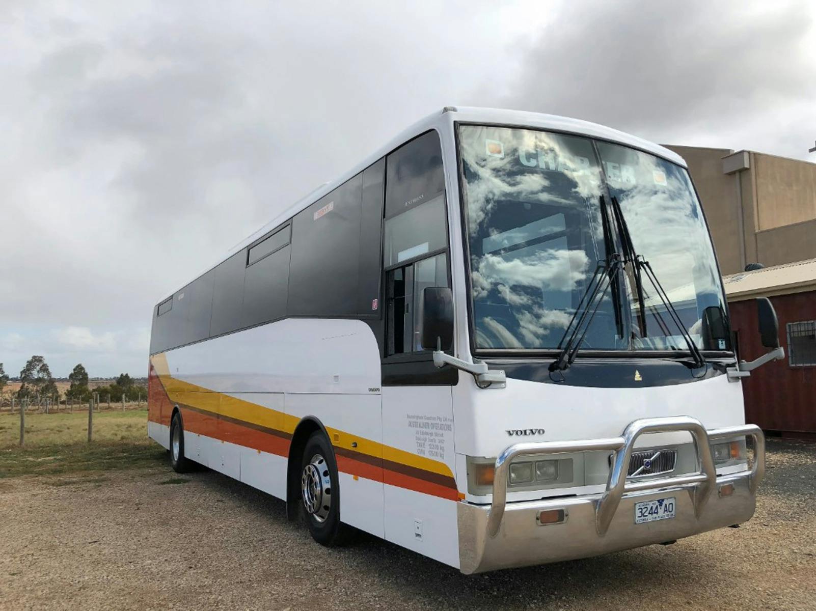 White high capacity coach with yellow and red stripe down the side