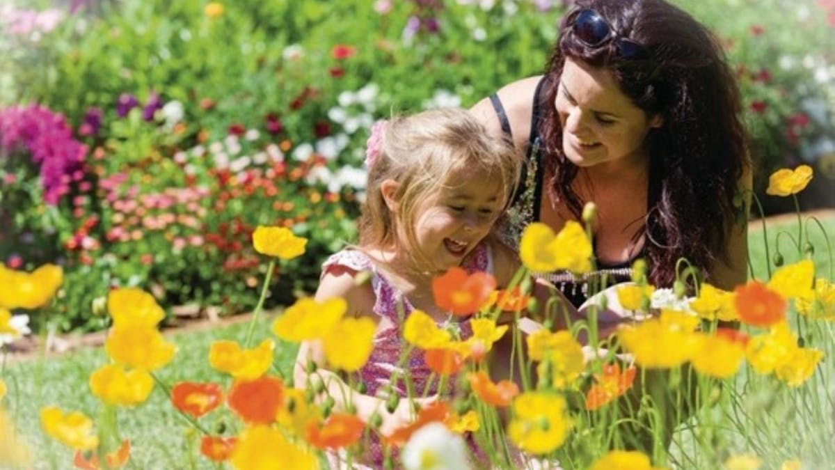 Lady and girl smelling flowers at Toowoomba Carnival of Flowers