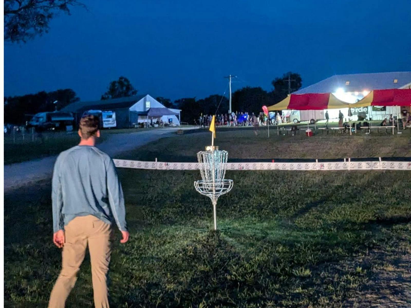 Man in front of disc golf course at night