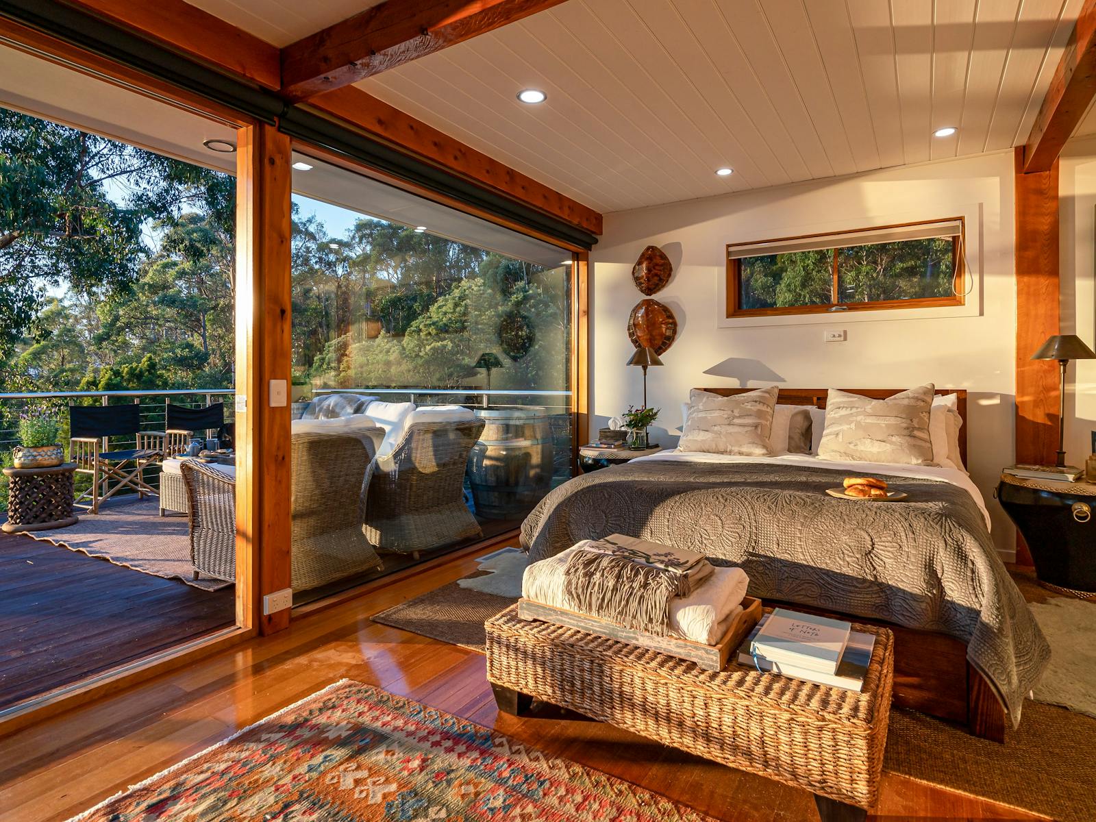 An interior photo of the Huon River Hideaway bedroom setting facing outwards through large windows