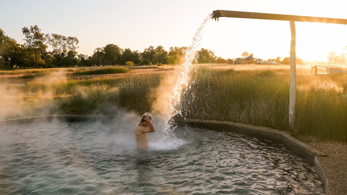 A man enjoying hot artesian water flowing into the bore at Charlotte Plains in Outback Queensland