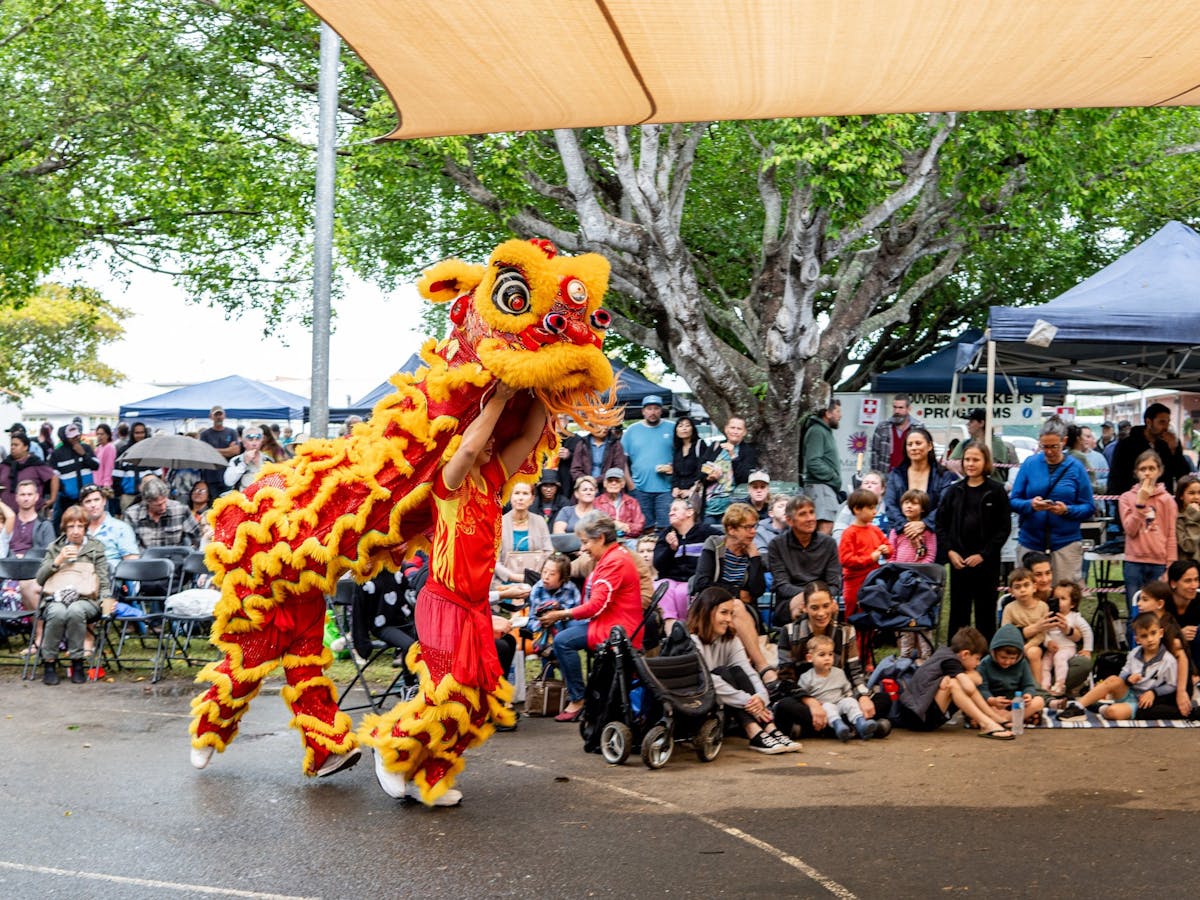Two men perform a traditional chinese dragon dance at the Mareeba Multicultural Festival.