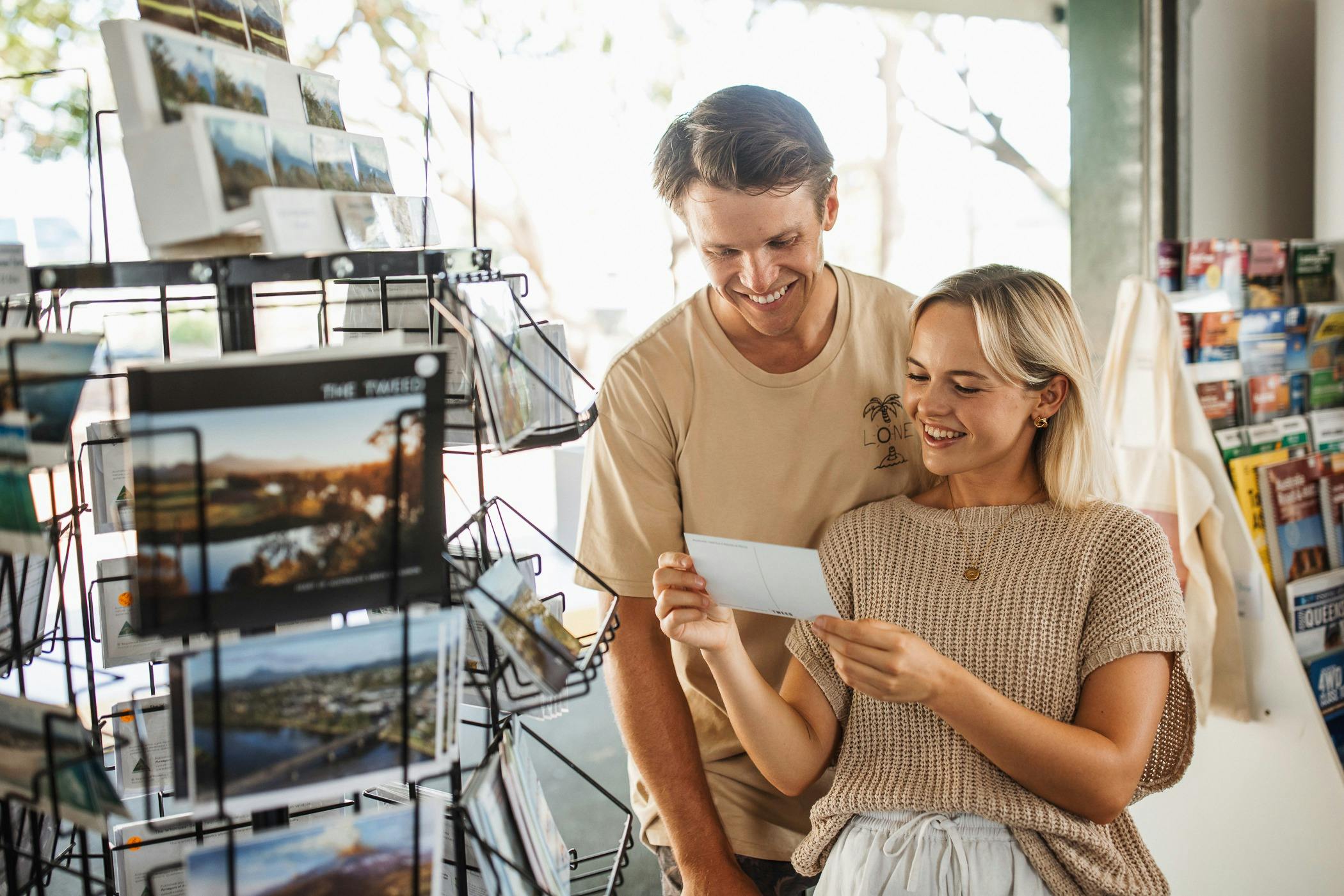 Couple looking at postcards in visitor information centre
