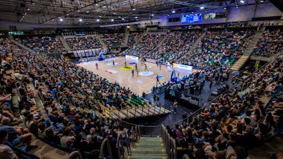 A full arena watching a UC Capitals game from the stands.