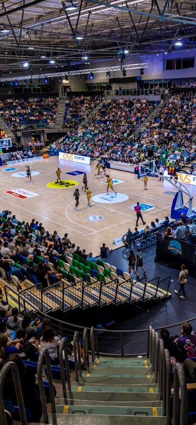 A full arena watching a UC Capitals game from the stands.
