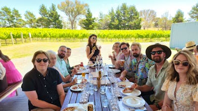 Group of friends posing for photo at Four Winds Vineyard on a Merry Heart CBR Great Tour