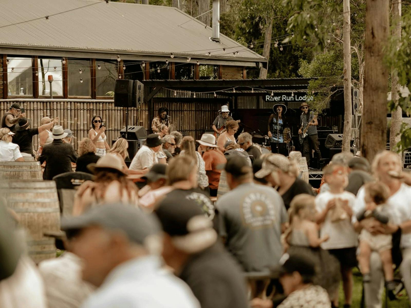 Crowd enjoying live music, food, and drinks at River Run Lodge in a relaxed, outdoor setting.