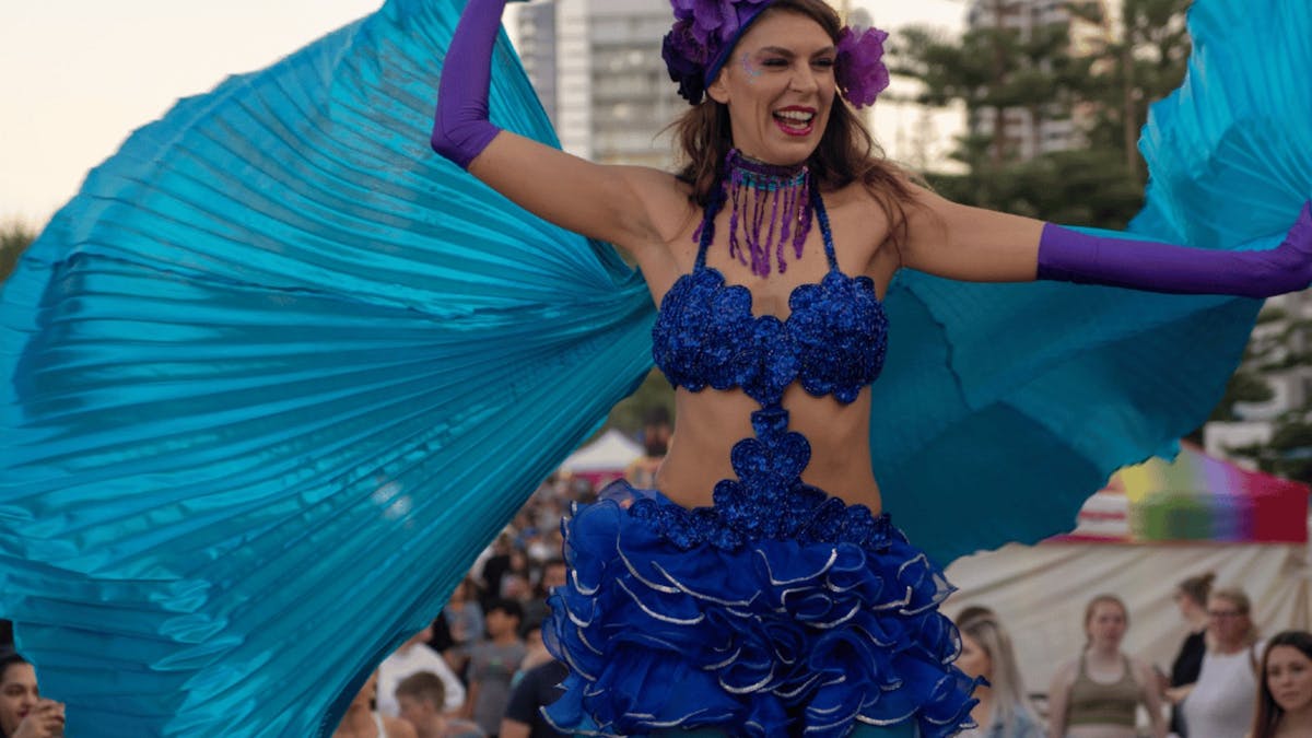 A lady on stilts wearing a blue fiesta themed outfit A lady on stilts wearing a blue fiesta themed outfit