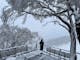 Person on snow covered deck overlooking ski slopes