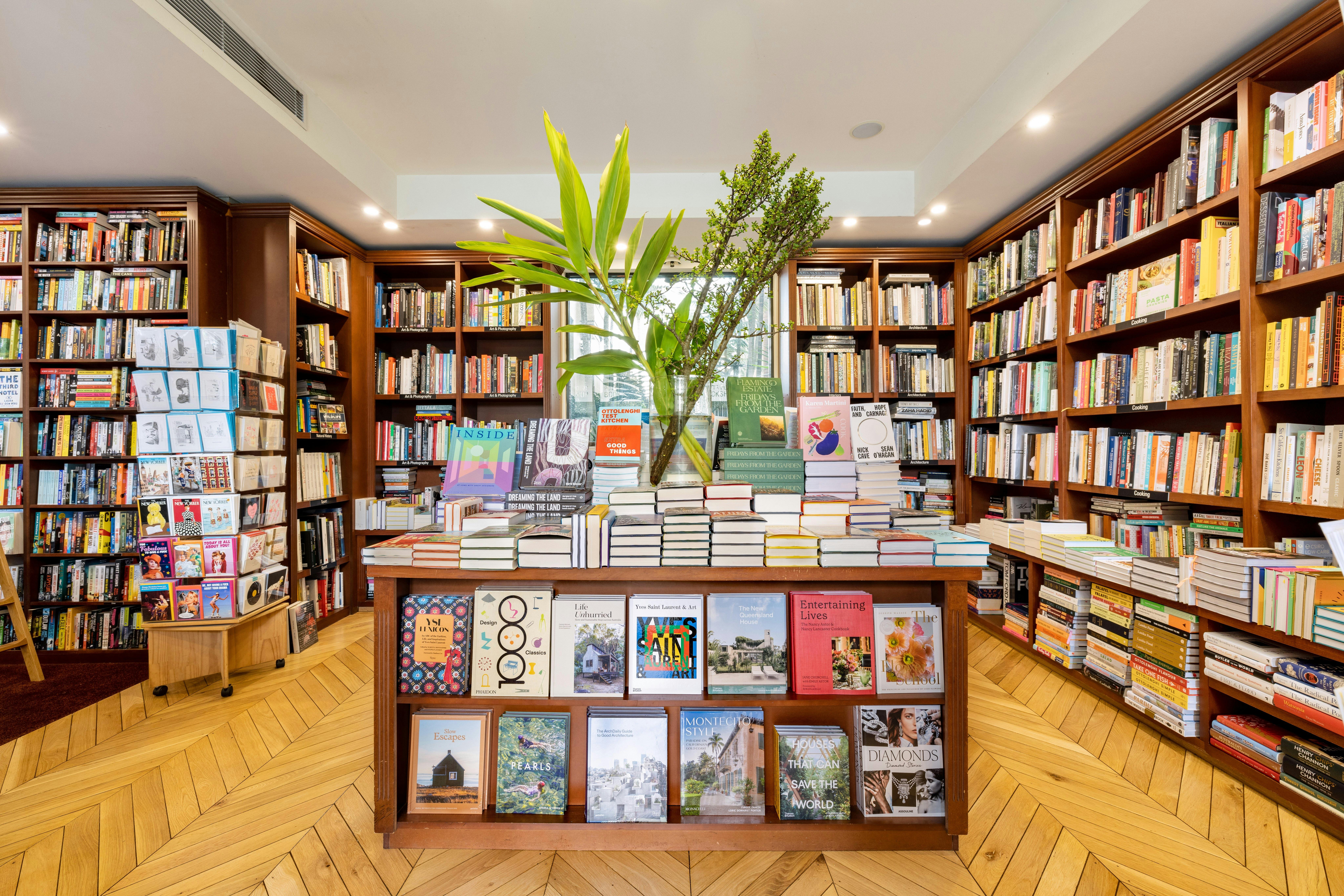 Books piles on table with beautiful flower display.