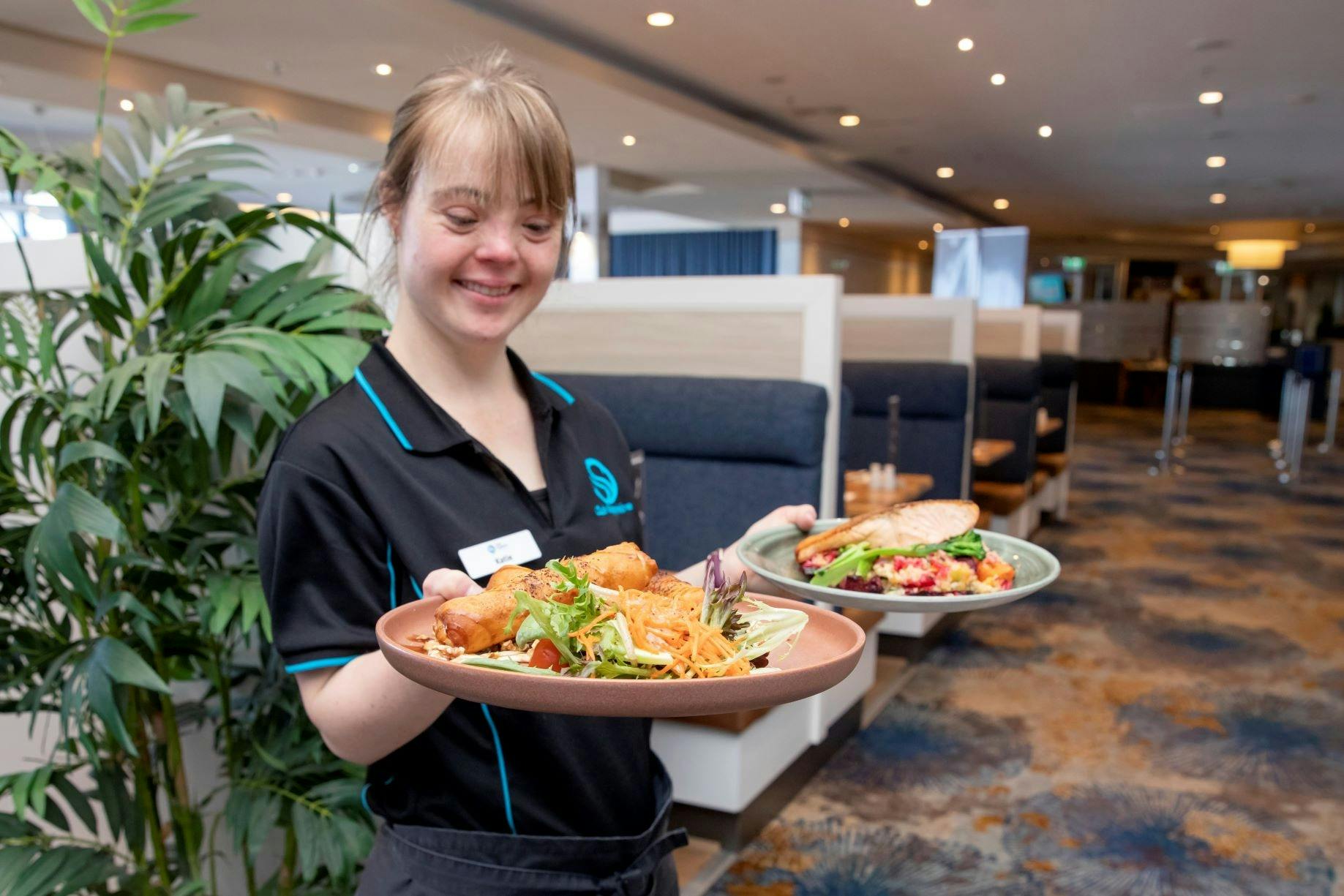 테이블에 음식을 제공하는 친절한 웨이트리스