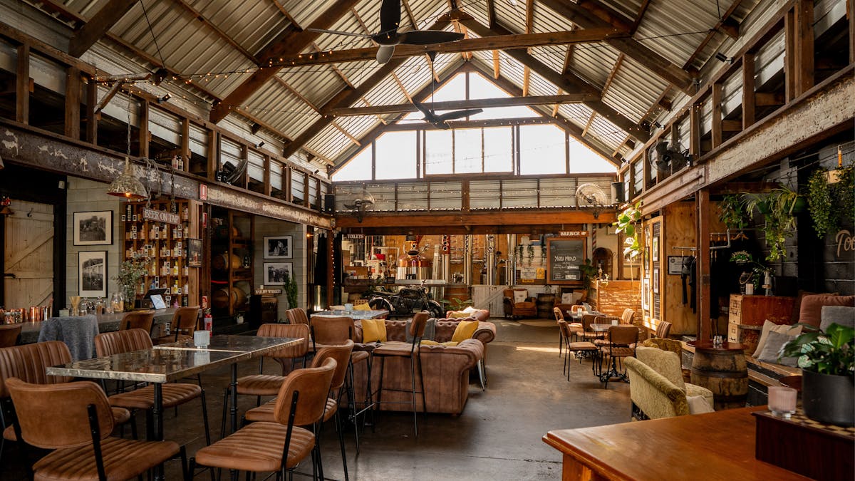 Interior view of Granddad Jack’s Craft Distillery with rustic seating and open space.