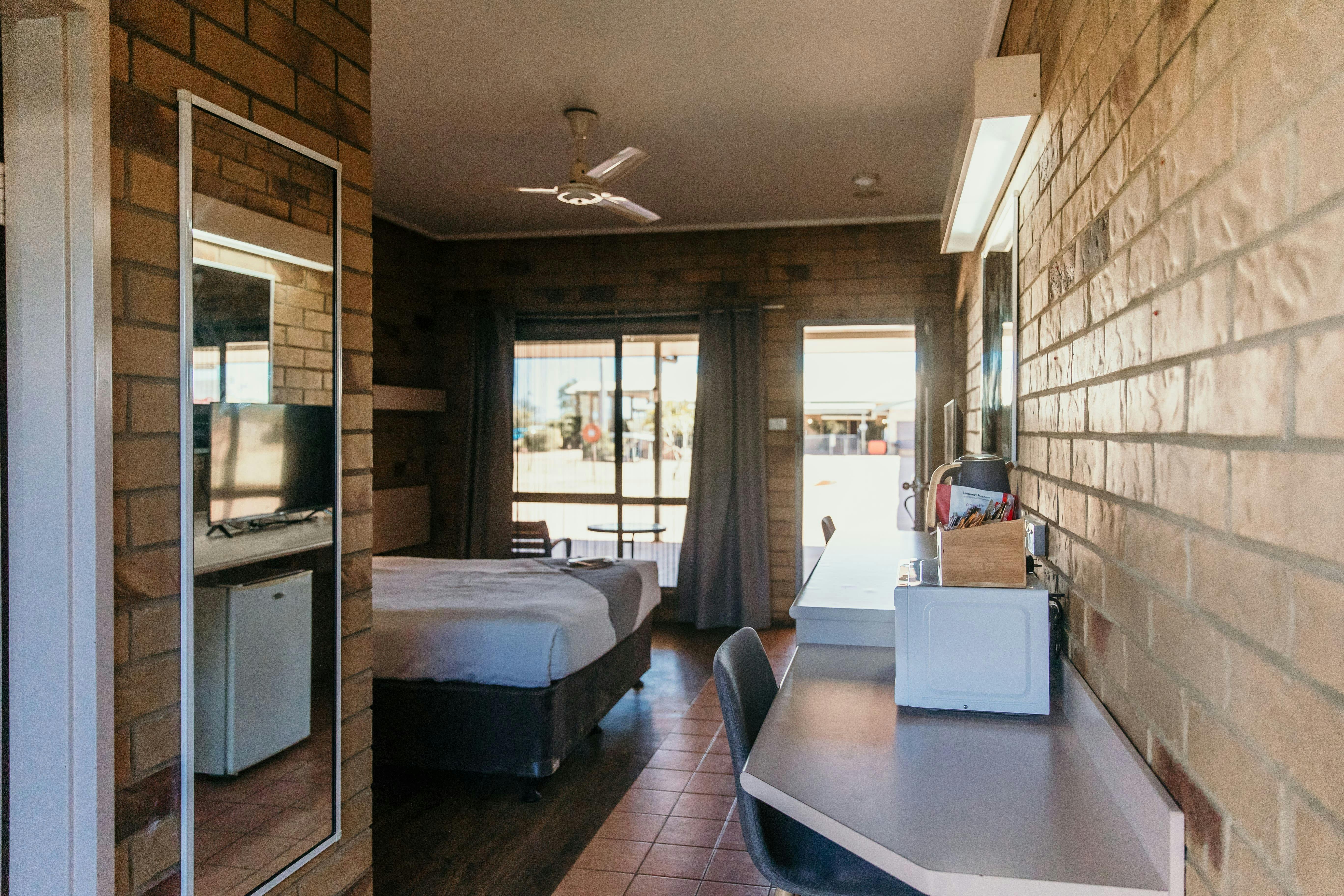 Queen Room view of room with mirror, microwave, windows and door.