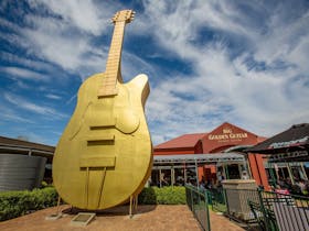 Photo of the Big Golden Guitar and Information Centre behind it
